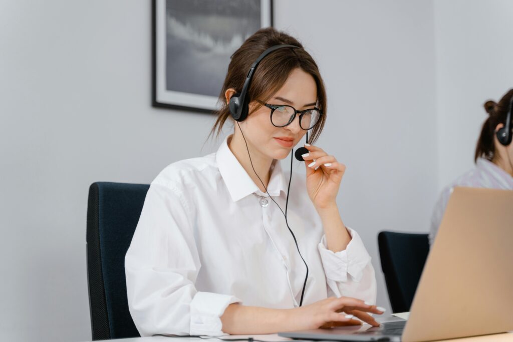 A support team member wearing a headset while working on a laptop
